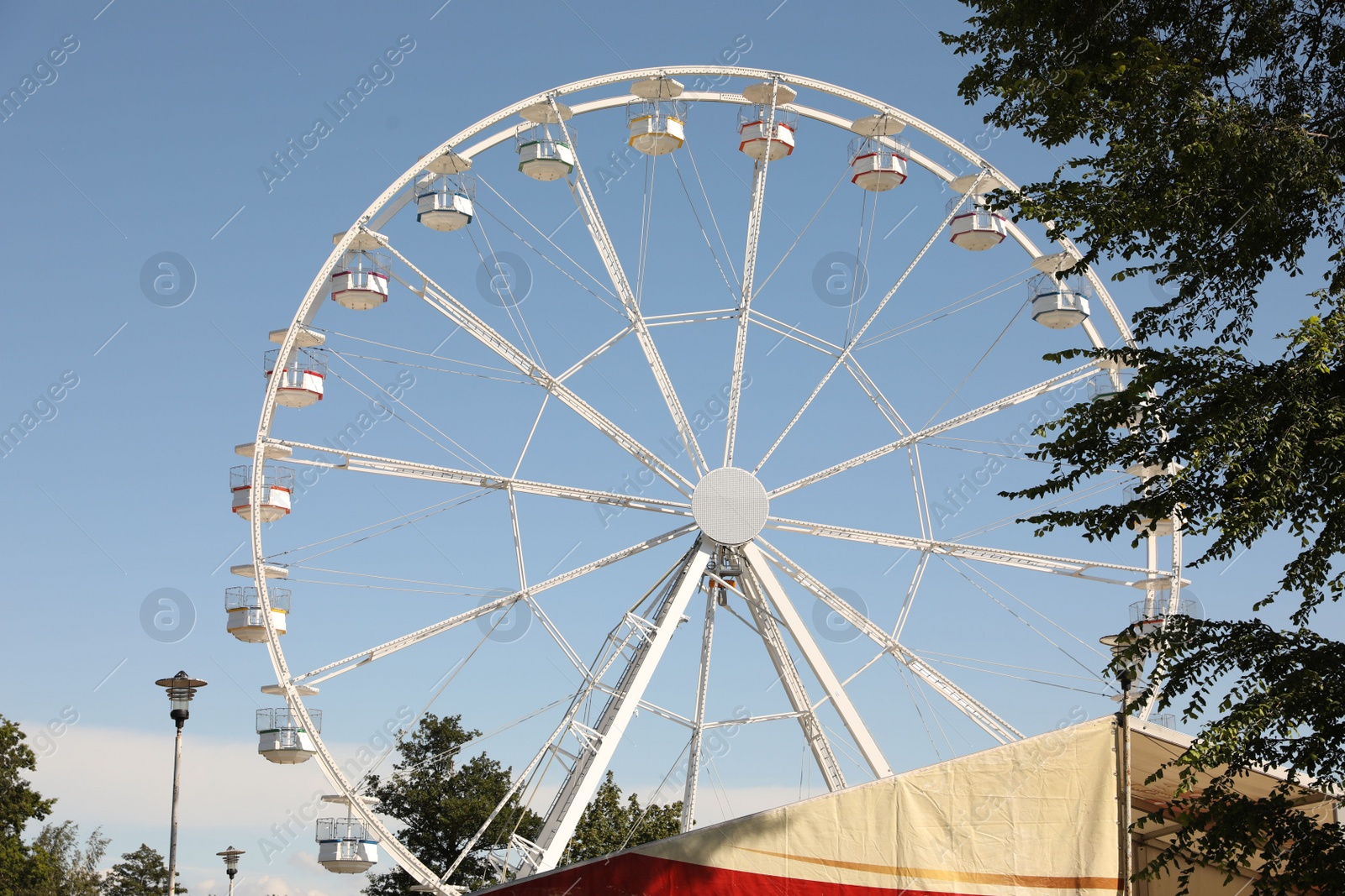 Photo of Beautiful white ferris wheel against blue sky