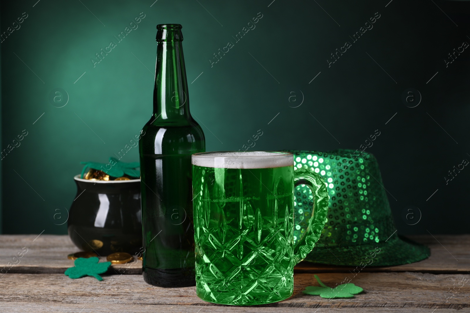 Photo of St. Patrick's day party. Green beer, leprechaun hat, pot of gold and decorative clover leaves on wooden table