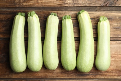 Photo of Raw green zucchinis on wooden table, flat lay