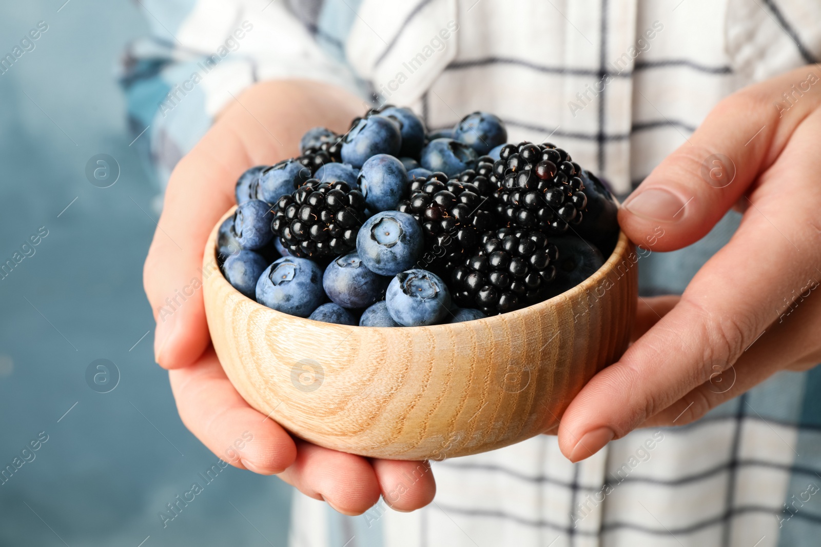 Photo of Woman with bowl of delicious summer berries, closeup