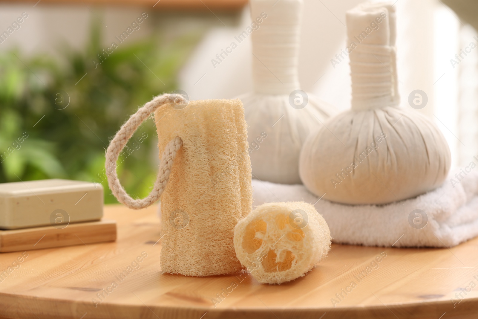 Photo of Loofah sponges on wooden table indoors, closeup. Personal hygiene products