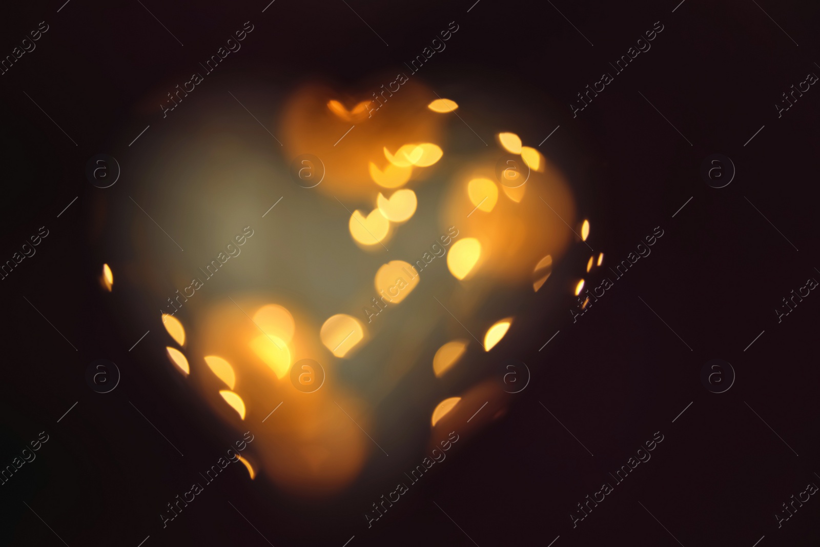 Photo of Blurred view of gold lights on dark background. Bokeh effect