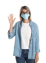 Photo of Woman in protective mask showing hello gesture on white background. Keeping social distance during coronavirus pandemic