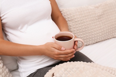 Photo of Pregnant woman drinking tea at home, closeup