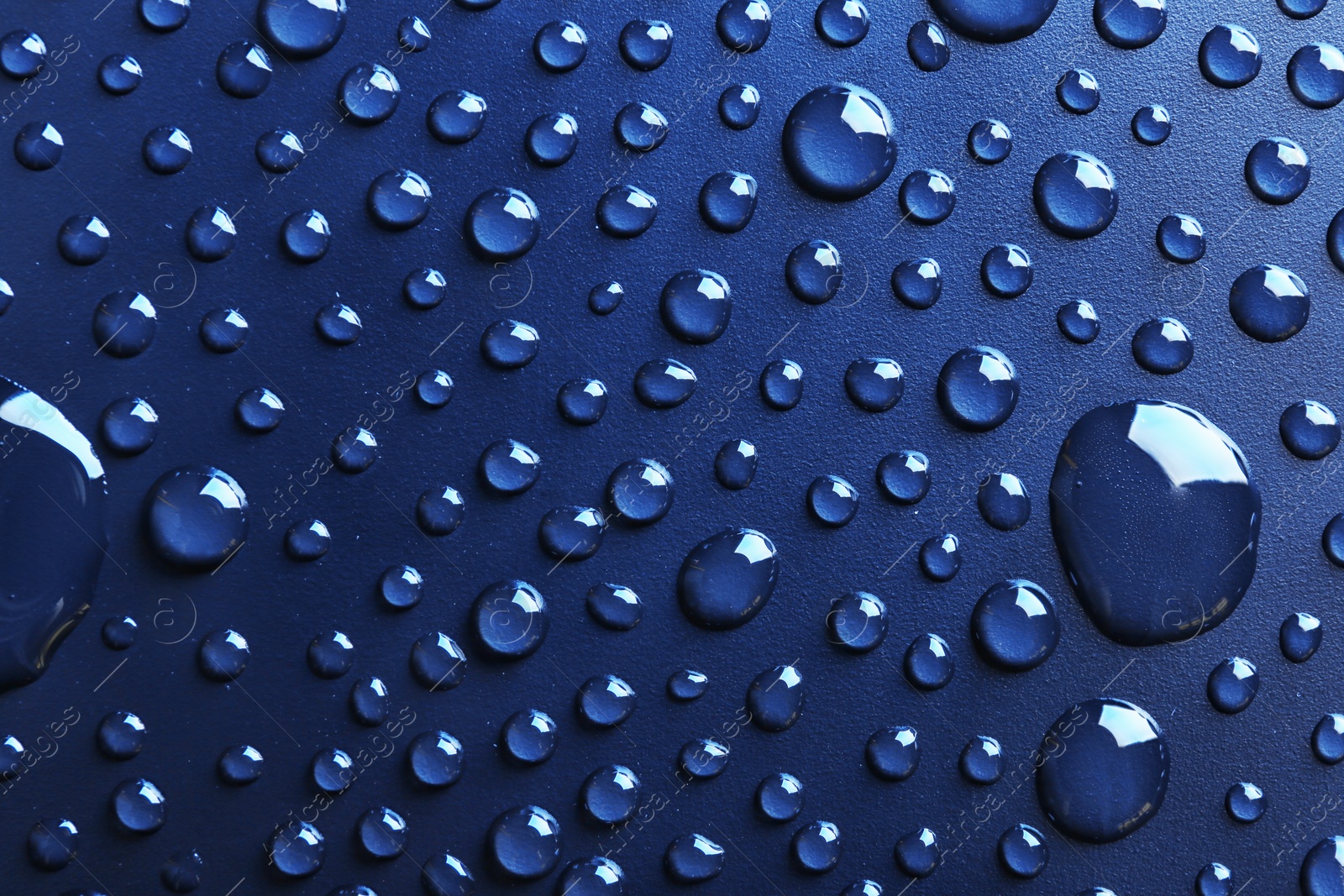 Photo of Water drops on dark background, top view