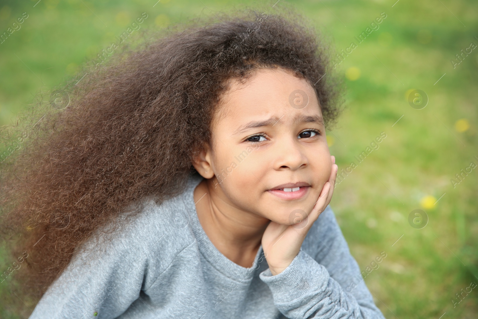 Photo of Cute African-American girl in stylish clothes posing outdoors