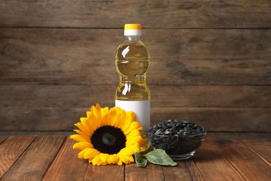 Sunflower cooking oil, seeds and yellow flower on wooden table