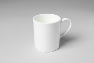Photo of White ceramic mug on light grey background