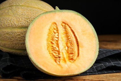 Photo of Tasty fresh melons on wooden table, closeup