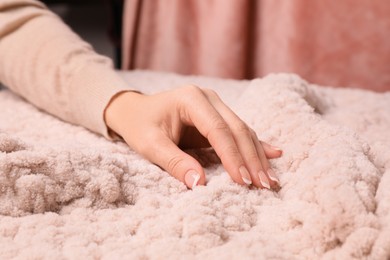Photo of Woman touching soft knitted fabric, closeup view