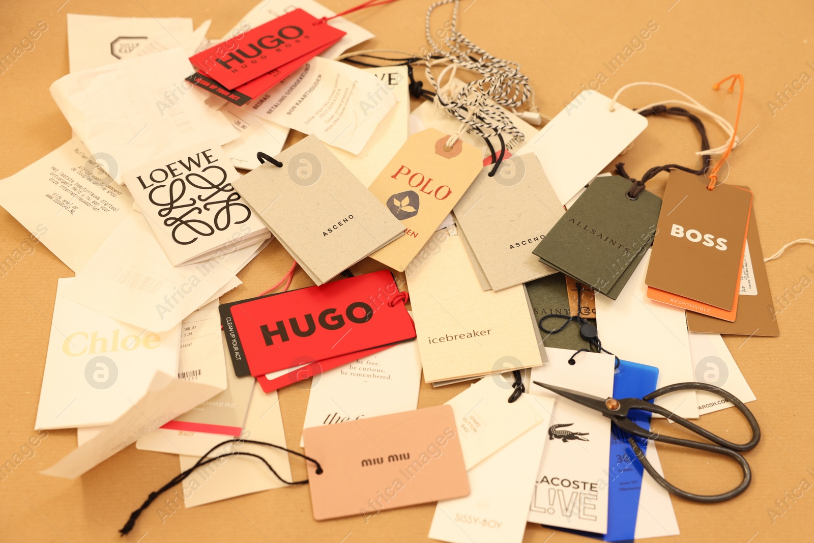 Photo of Leiden, Netherlands - December 6, 2023: Different clothing tags and scissors on kraft paper sheet