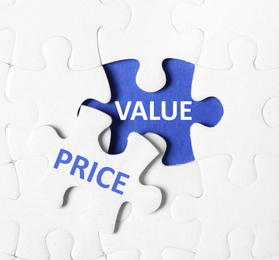 Image of Puzzle with phrase PRICE VALUE on blue background, top view