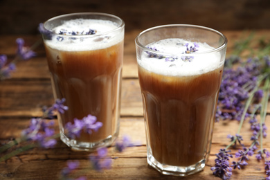 Photo of Delicious coffee with lavender on wooden table