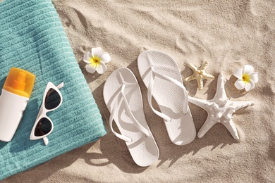 Flat lay composition with beach accessories on sand