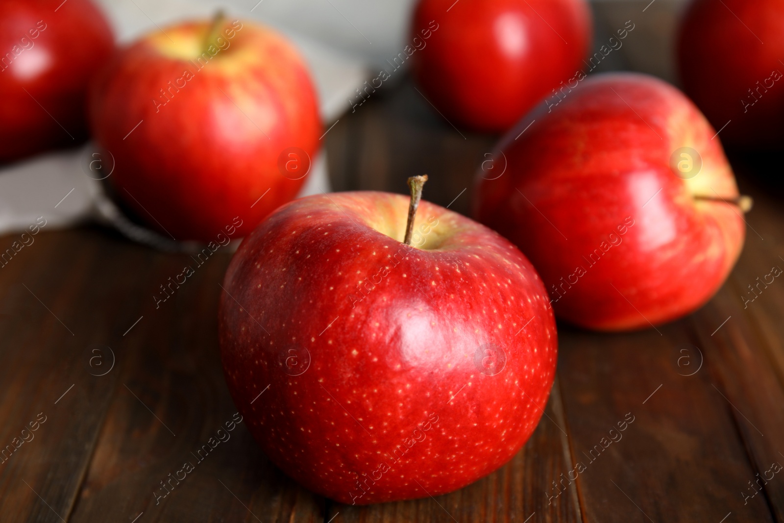 Photo of Ripe red apples on wooden table, closeup