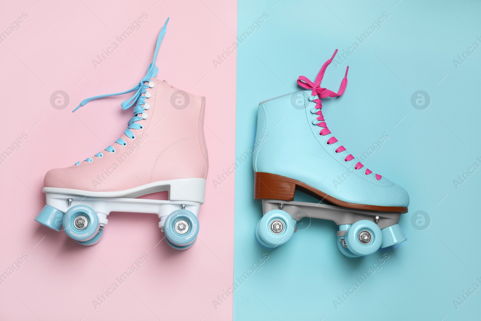 Photo of Pair of stylish quad roller skates on color background, top view