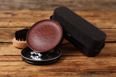 Photo of Shoe care accessories on wooden background, closeup