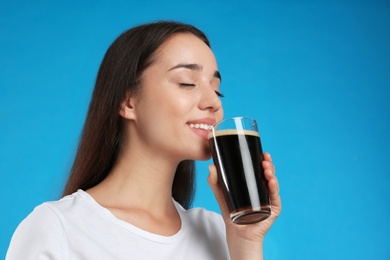 Beautiful woman with cold kvass on blue background. Traditional Russian summer drink