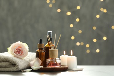 Composition with different spa products and rose flower on light table, space for text