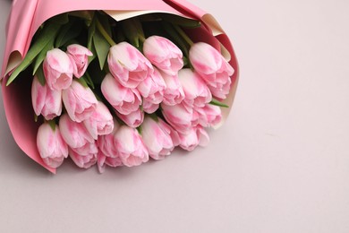 Photo of Beautiful bouquet of fresh pink tulips on light background. Space for text