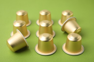 Many coffee capsules on green background, closeup