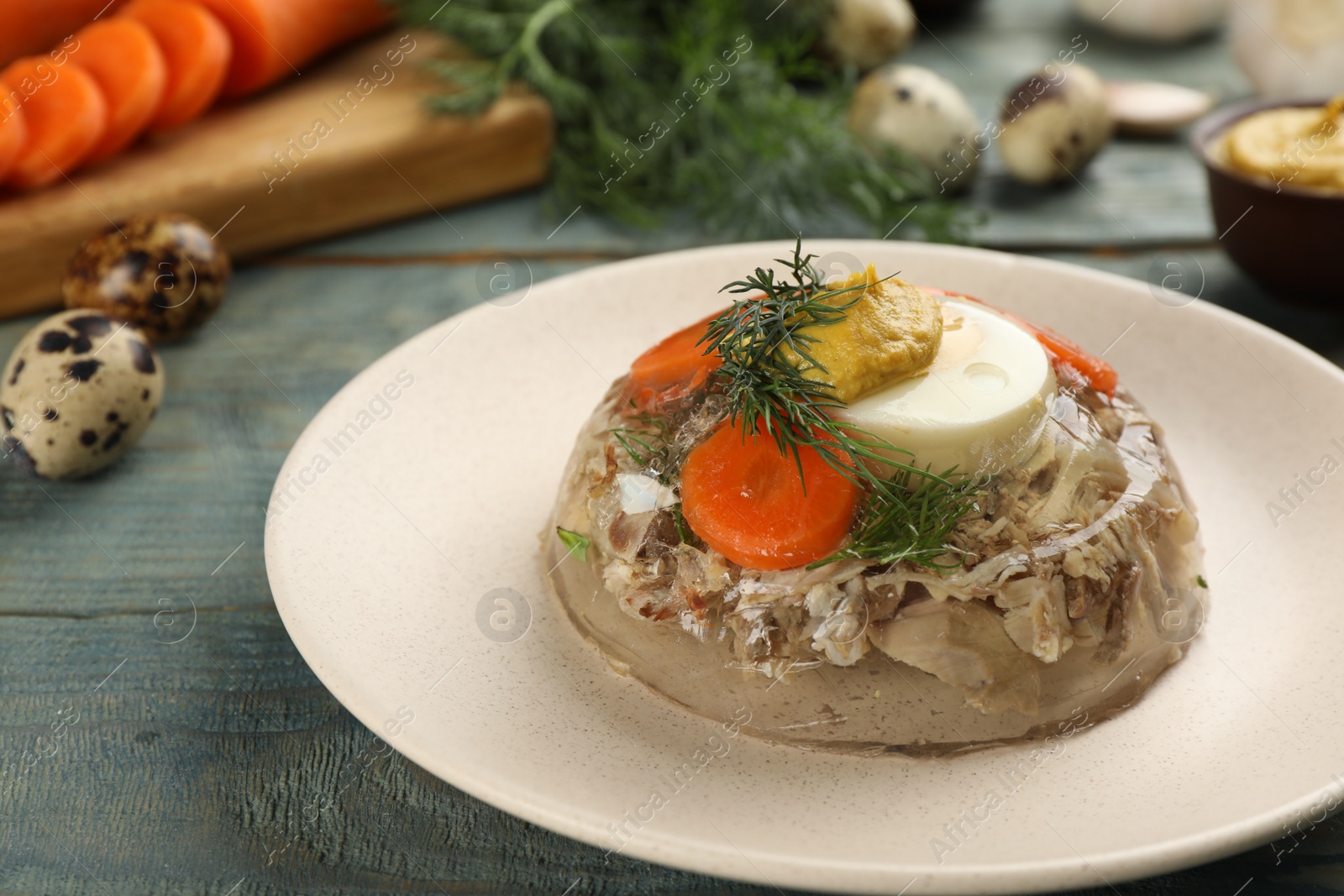 Photo of Plate with delicious aspic on light blue wooden table, closeup