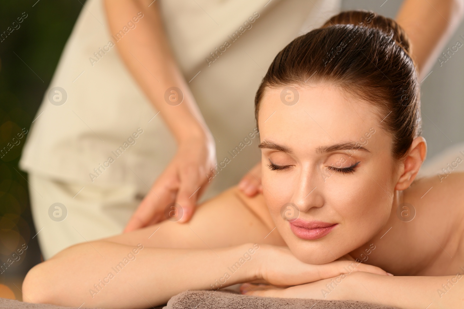 Photo of Beautiful young woman enjoying massage in spa salon