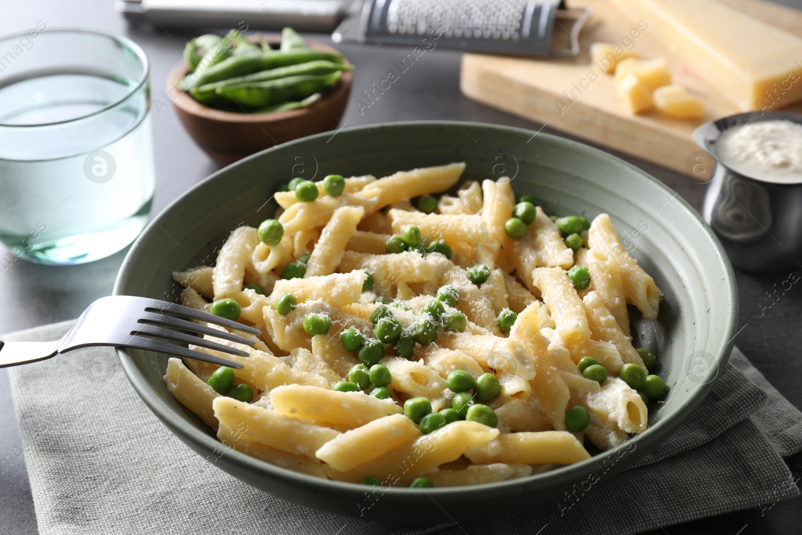 Photo of Delicious pasta with green peas served on table, closeup