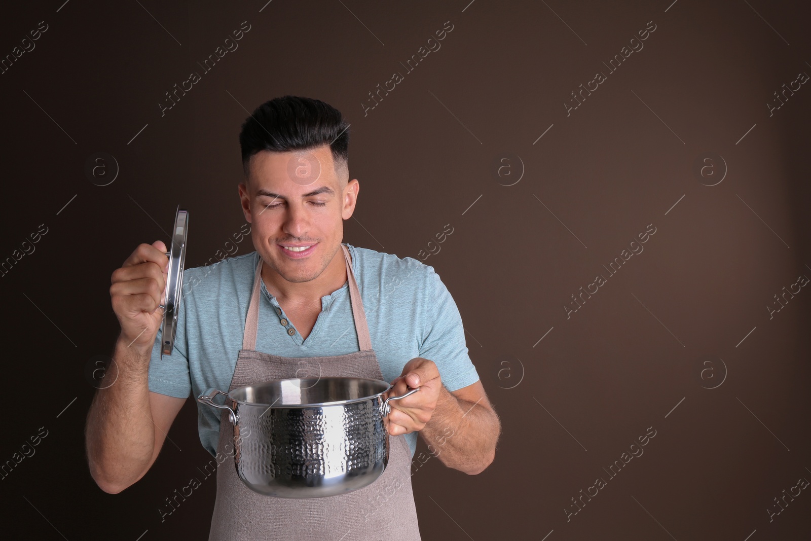 Photo of Handsome man with pot on brown background, space for text