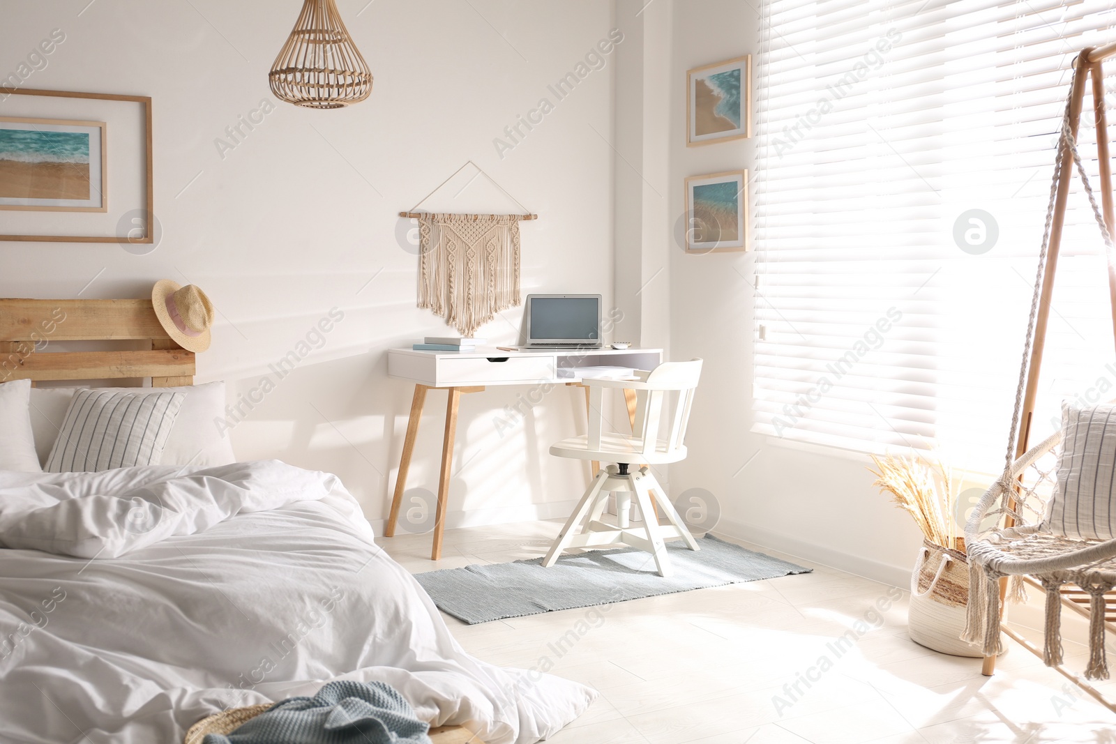 Photo of Stylish room interior with workplace, hanging chair and bed