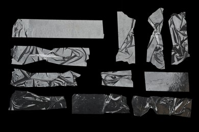 Photo of Many pieces of transparent adhesive tape on black background, flat lay