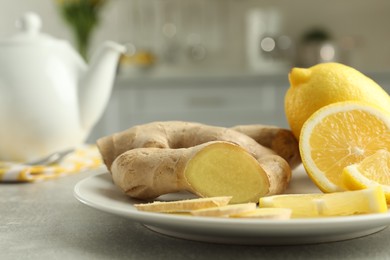 Fresh lemons and ginger on grey table indoors, closeup