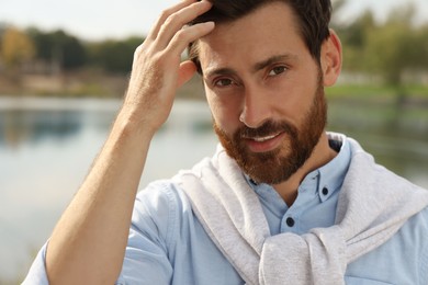 Photo of Portrait of handsome bearded man near lake