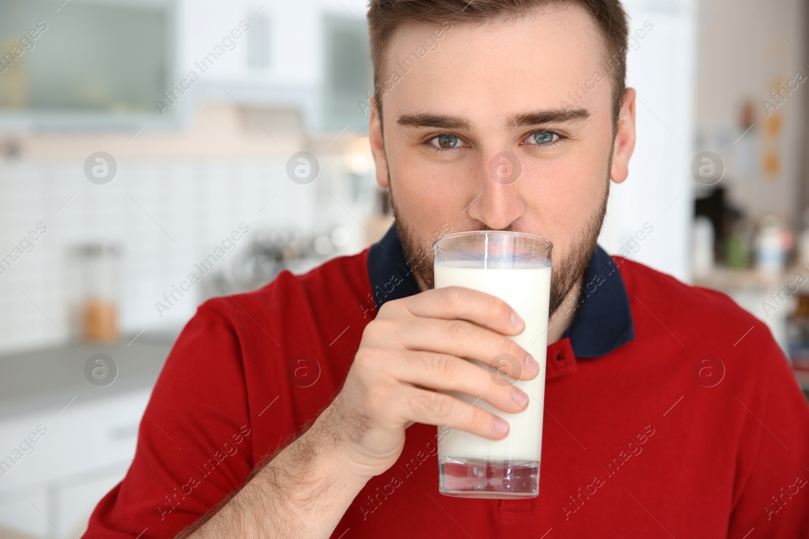 Photo of Young man drinking tasty milk at home