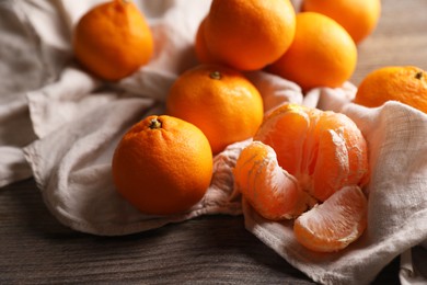 Photo of Many fresh ripe tangerines on wooden table, closeup