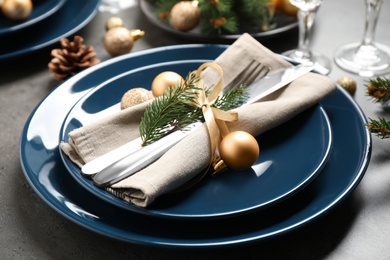 Festive table setting with beautiful dishware and Christmas decor on grey background