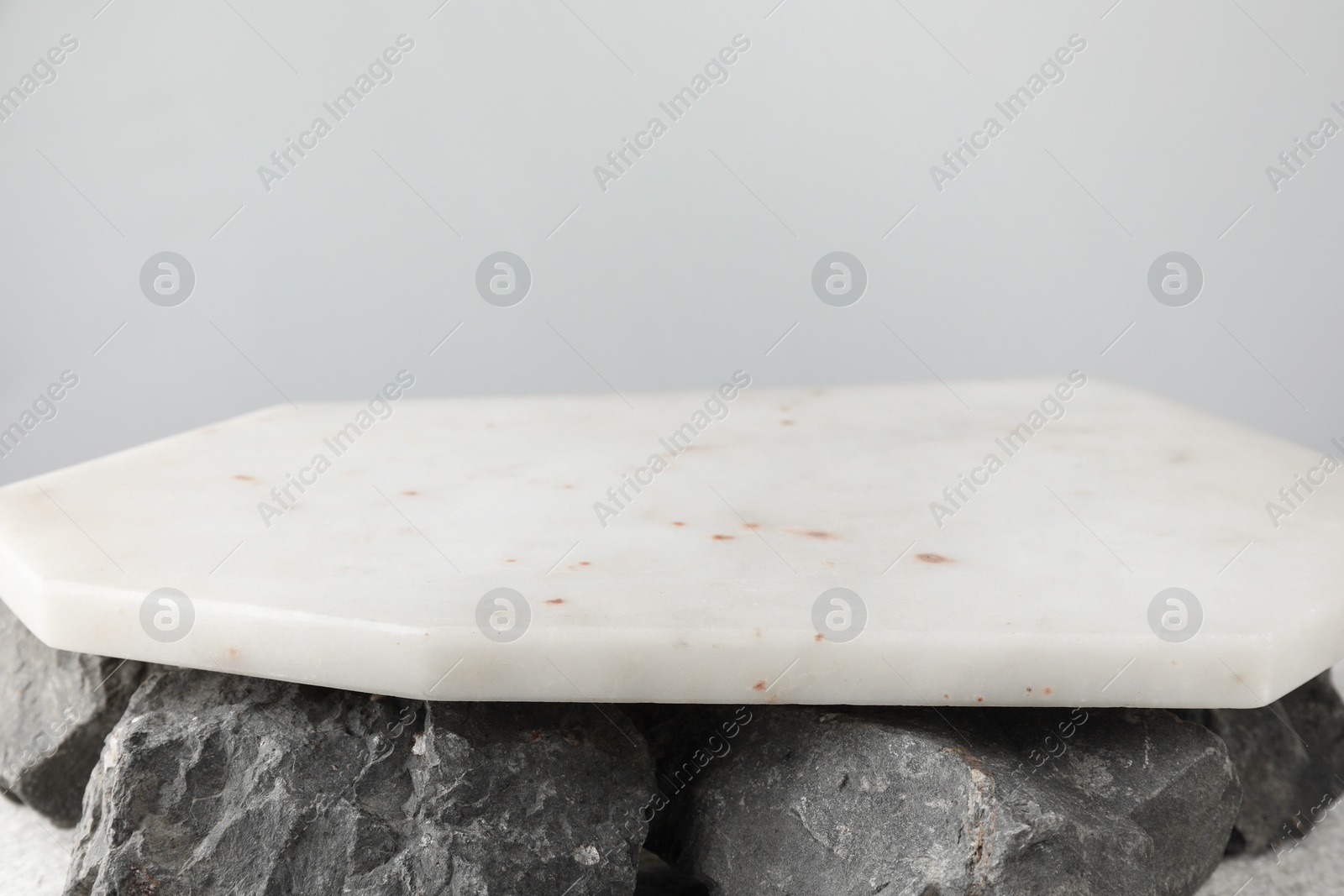 Photo of Presentation for product. Marble podium and stones on grey background, closeup