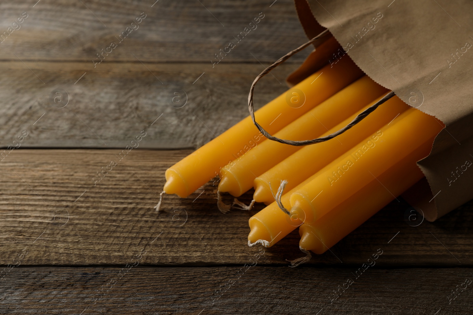 Photo of Many church wax candles on wooden table, space for text