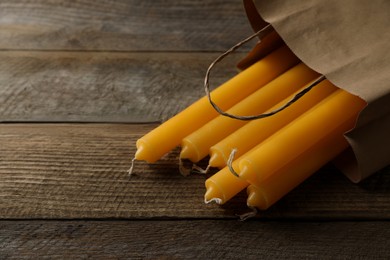 Many church wax candles on wooden table, space for text