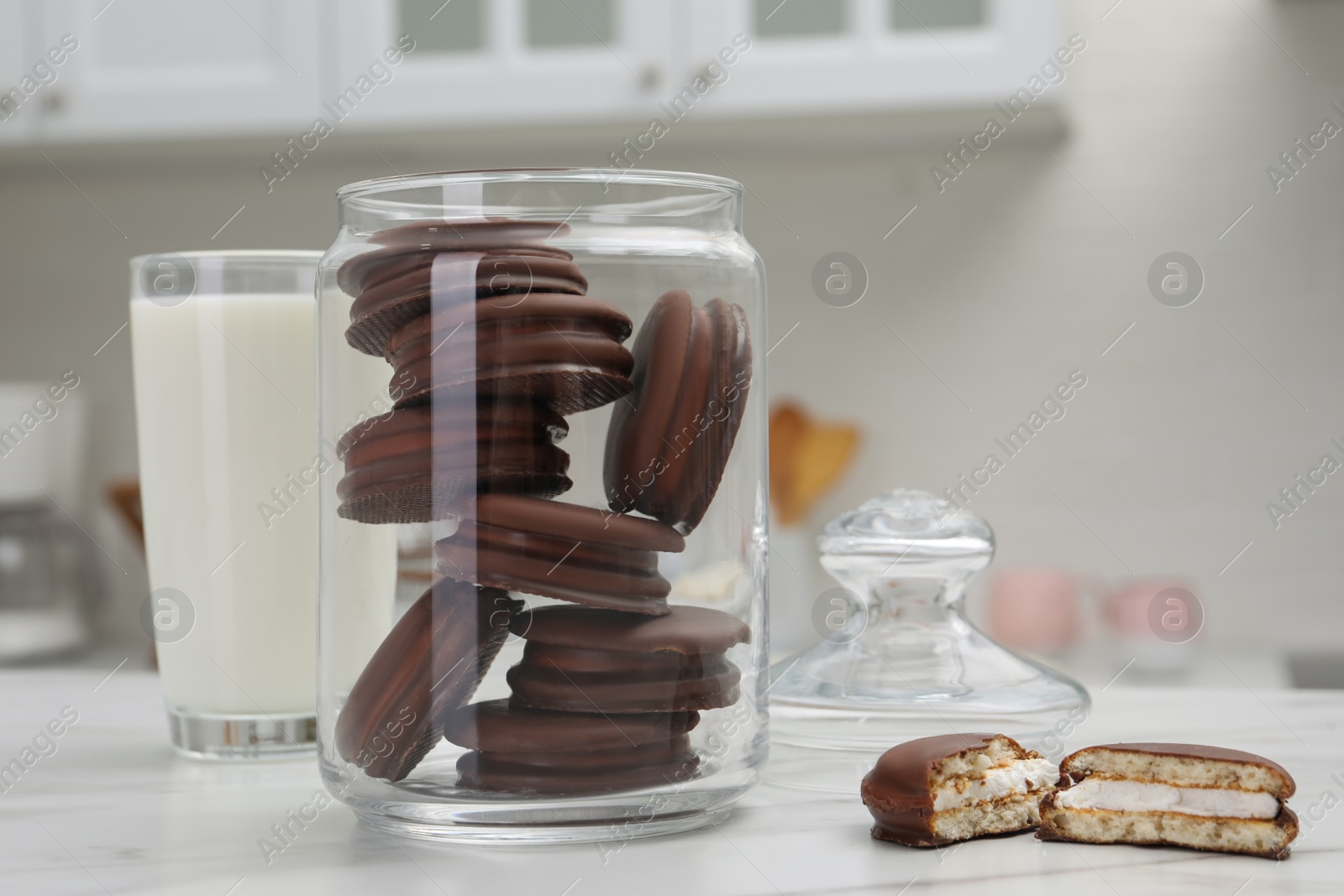 Photo of Jar with delicious choco pies and glass of milk on white table in kitchen