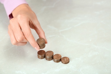 Photo of Woman counting coins at light table, closeup