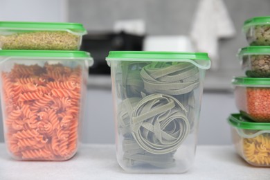 Photo of Plastic containers filled with food products on light table indoors, closeup