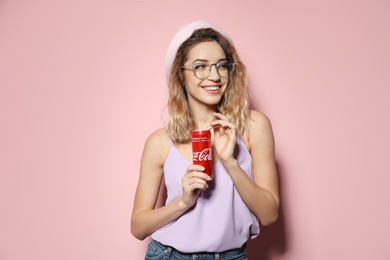 Photo of MYKOLAIV, UKRAINE - NOVEMBER 28, 2018: Young woman with Coca-Cola can on color background