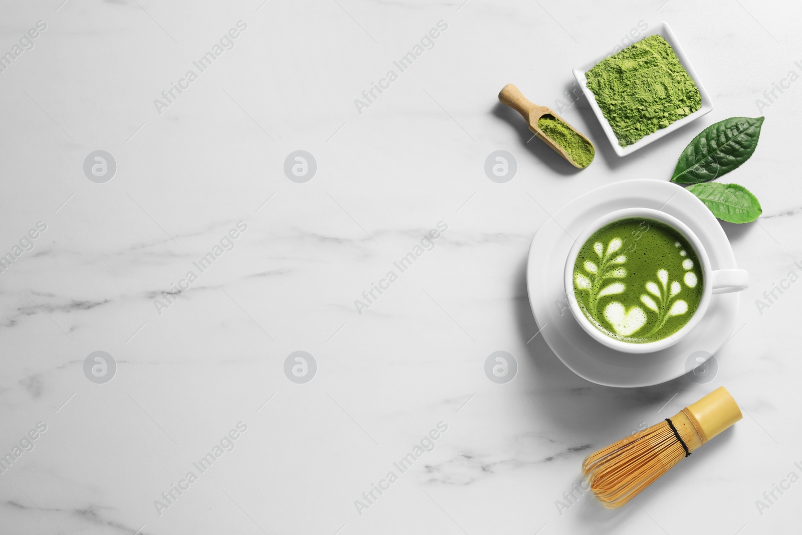 Photo of Delicious matcha latte, powder and leaves on white marble table, flat lay. Space for text