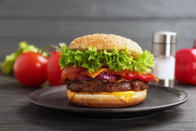 Photo of Plate with tasty burger on wooden table