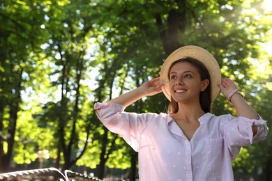 Young woman in park on sunny day, space for text