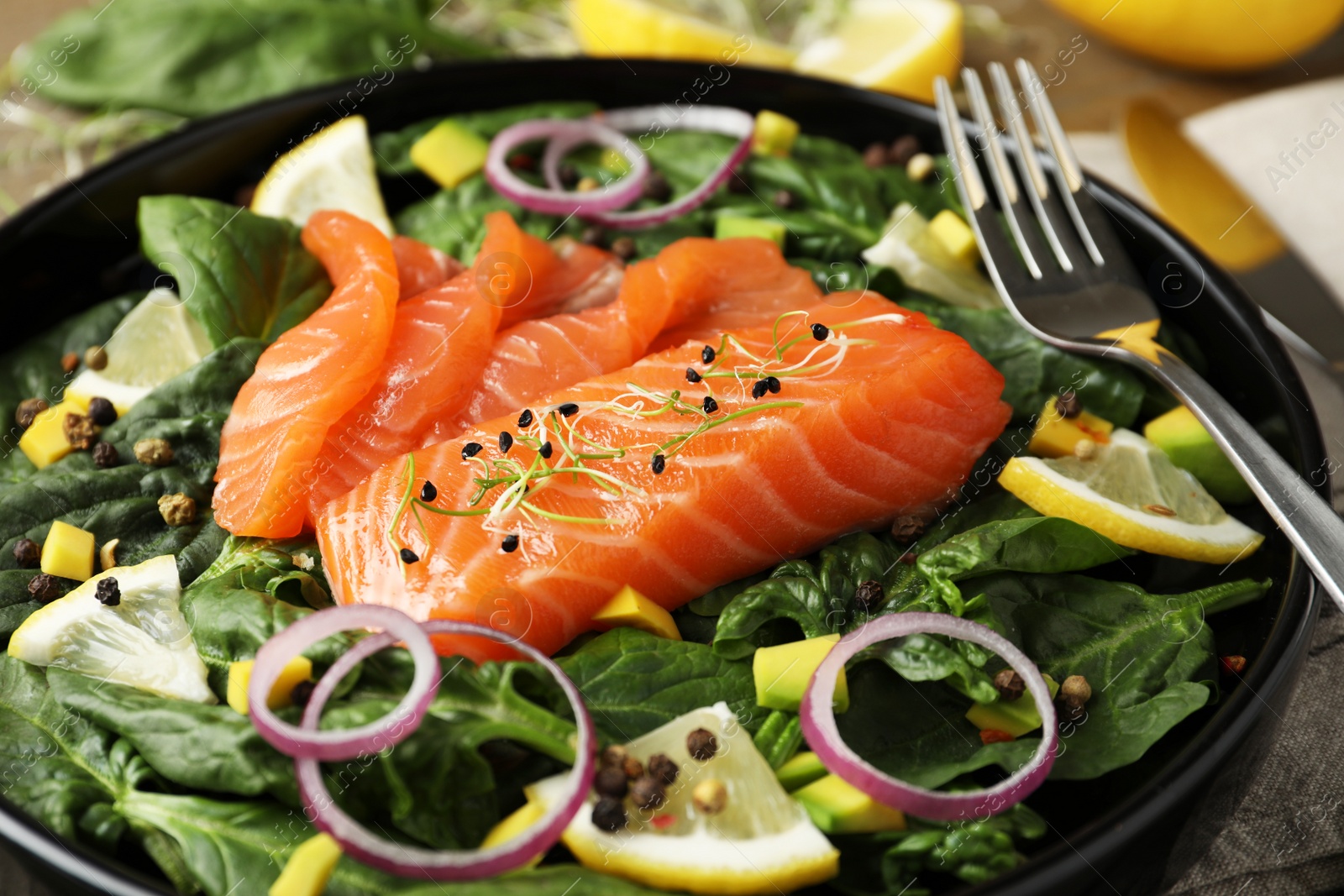 Photo of Delicious fresh salmon with spinach on plate, closeup