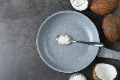 Photo of Flat lay composition with frying pan and organic coconut cooking oil on grey table, space for text