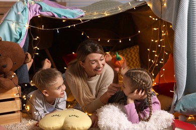 Mother and her children in play tent at home