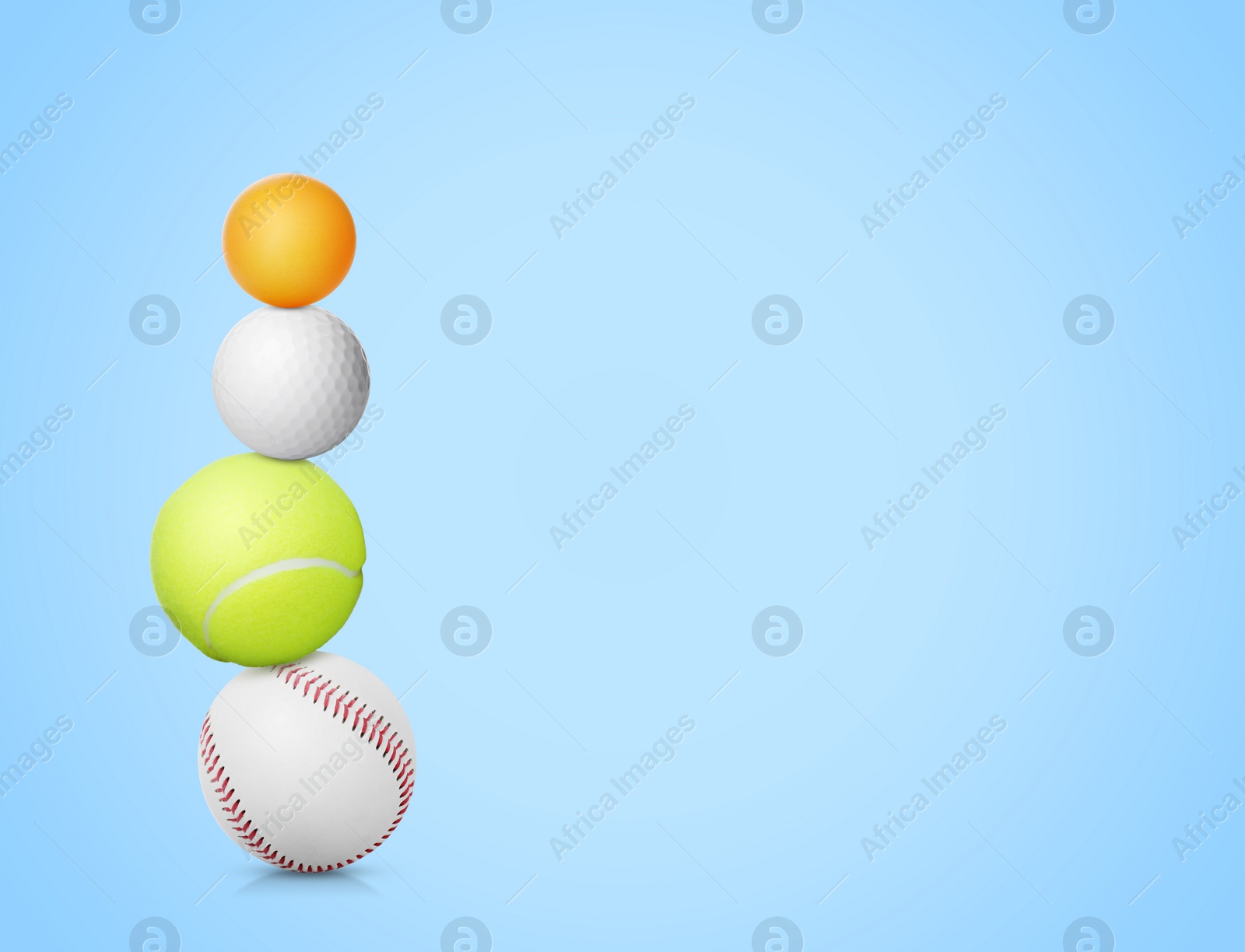 Image of Stack of different sport balls on light blue background, space for text